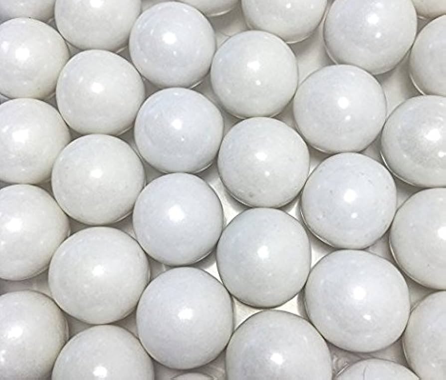 Close-up of white metallic gumballs on a light background